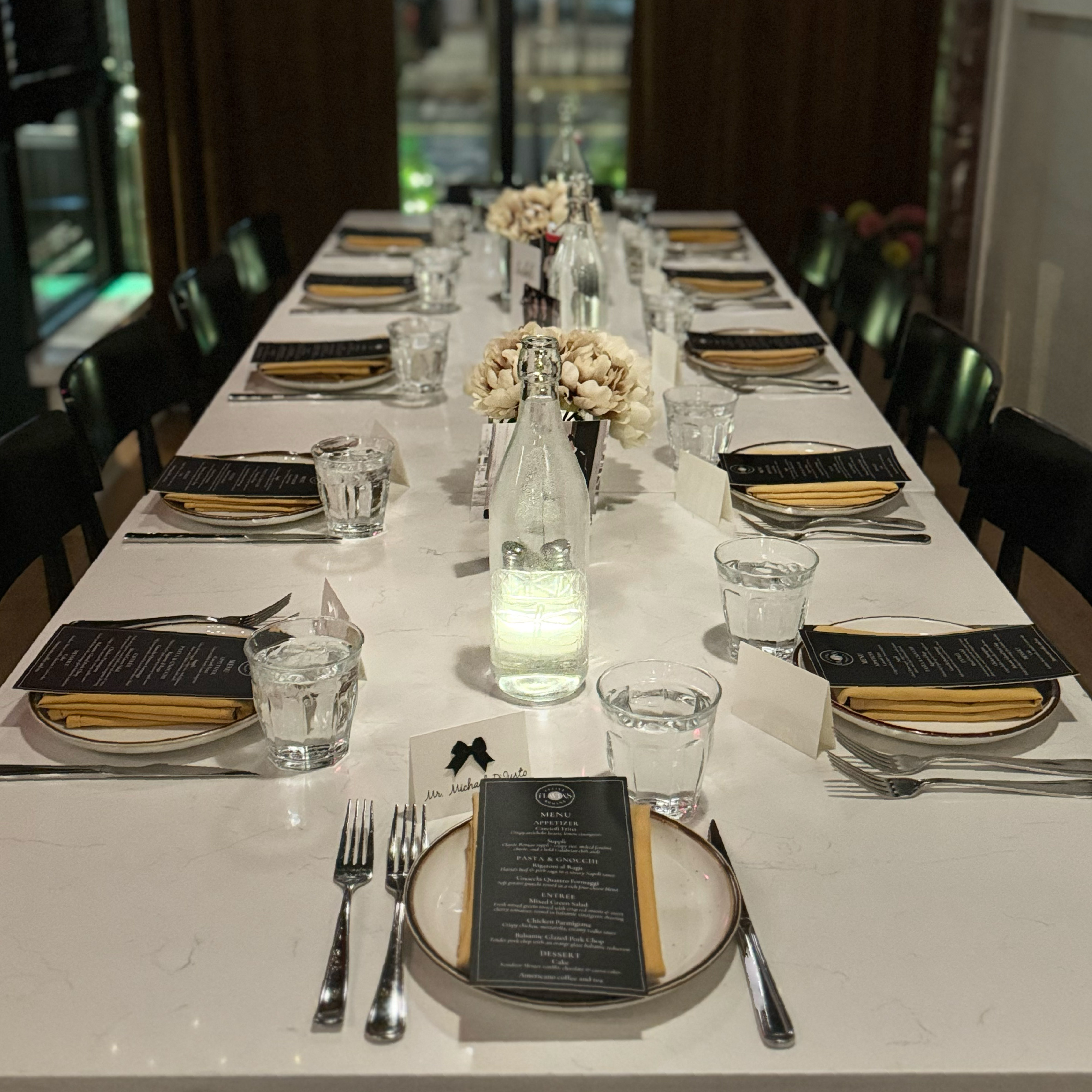 Private event table setup with menus and place settings at Flavia’s